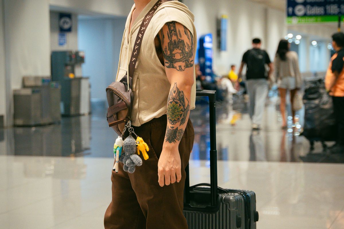 Travelers walking through an airport arrivals hall with luggage